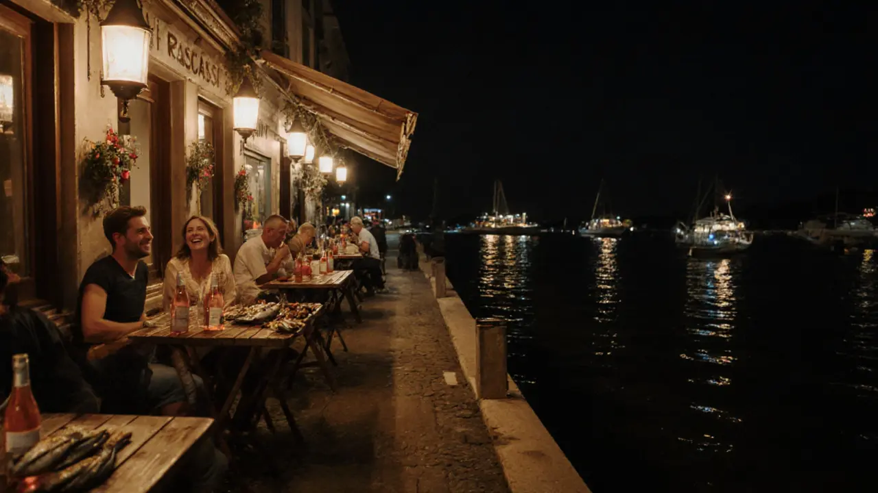 Locals enjoying grilled seafood and rosé at Le Rascasse waterfront bar under soft lantern light.